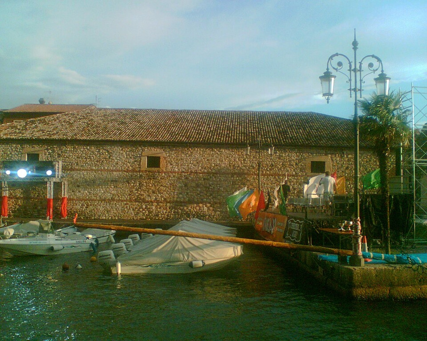 Il palo della cuccagna allestito sull'acqua del porto, davanti alla Dogana Veneta di Lazise